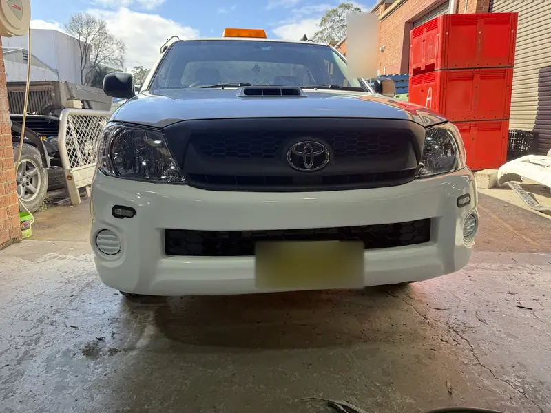 Repaired Toyota Hilux front end straight on, with refitted grille, headlights and bumper