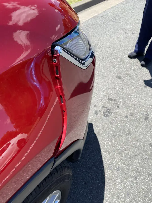 Close-up of the cracked Outlander bumper and chrome trim